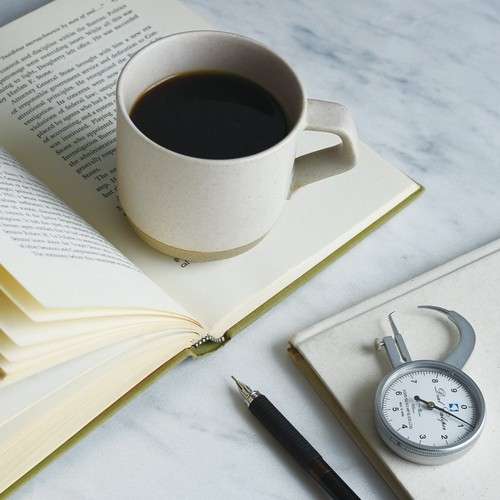 Taza y libreta en un espacio tranquilo con luz suave